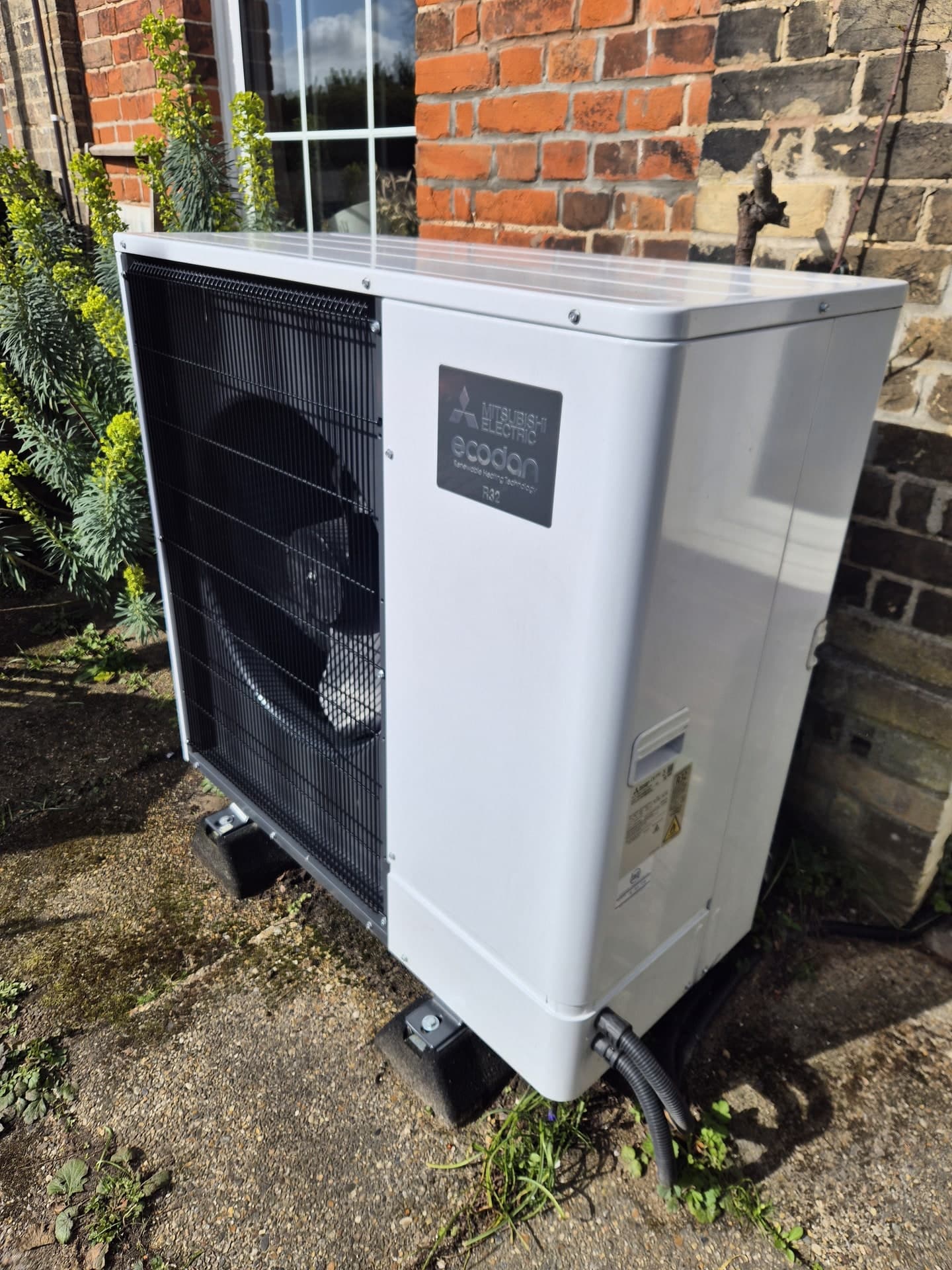 Mitsubishi Ecodan air source heat pump installed outside a brick home